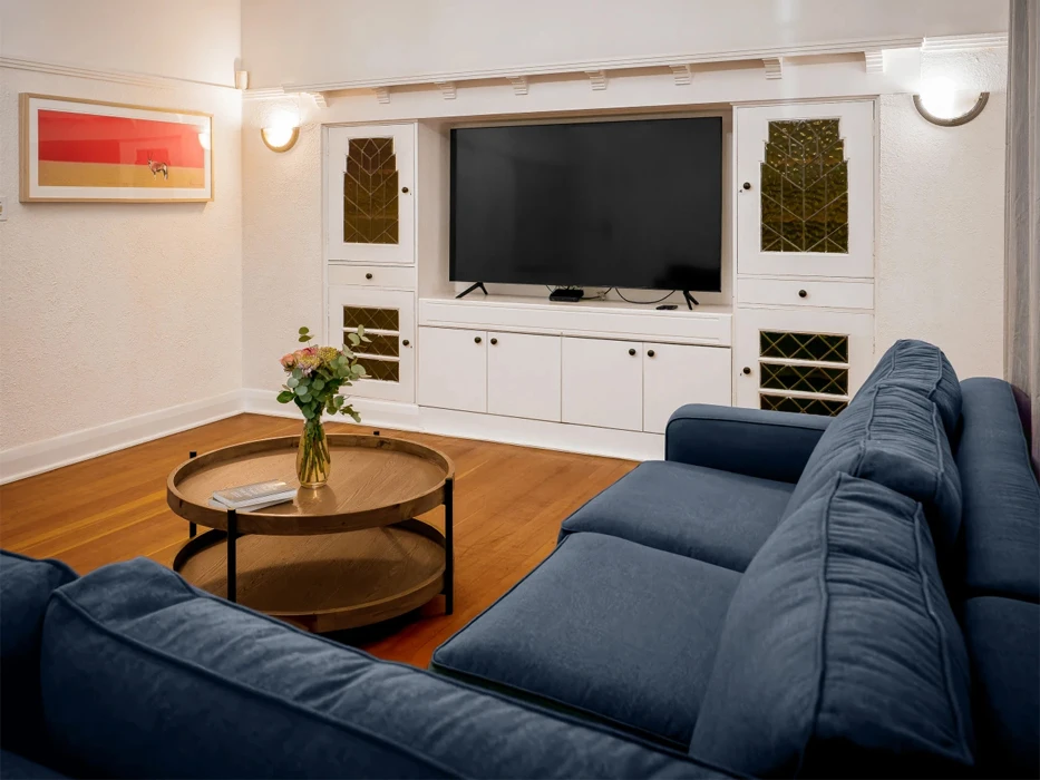 Rehab centre living room with blue couch and large flat screen TV.