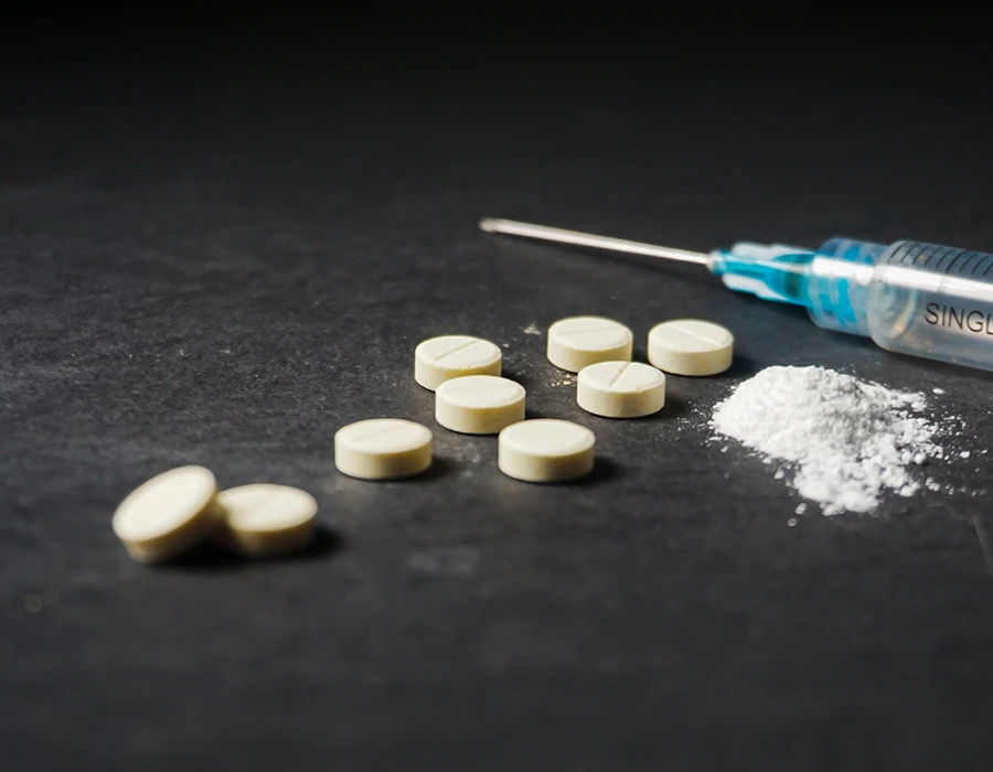 Pills, powder and a syringe representing benzo fury addiction.