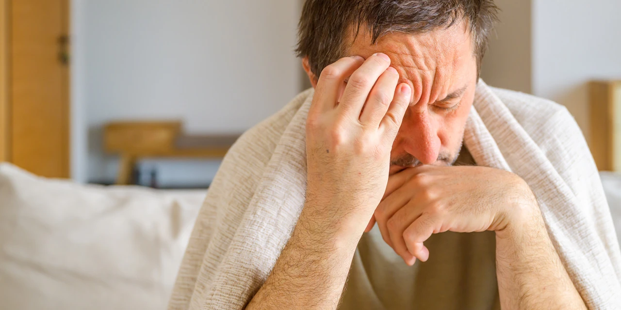 Man experiencing physical discomfort and possible alcohol-related symptoms.