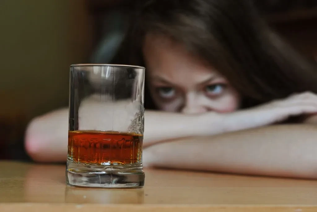 woman-staring-at-glass-alcohol