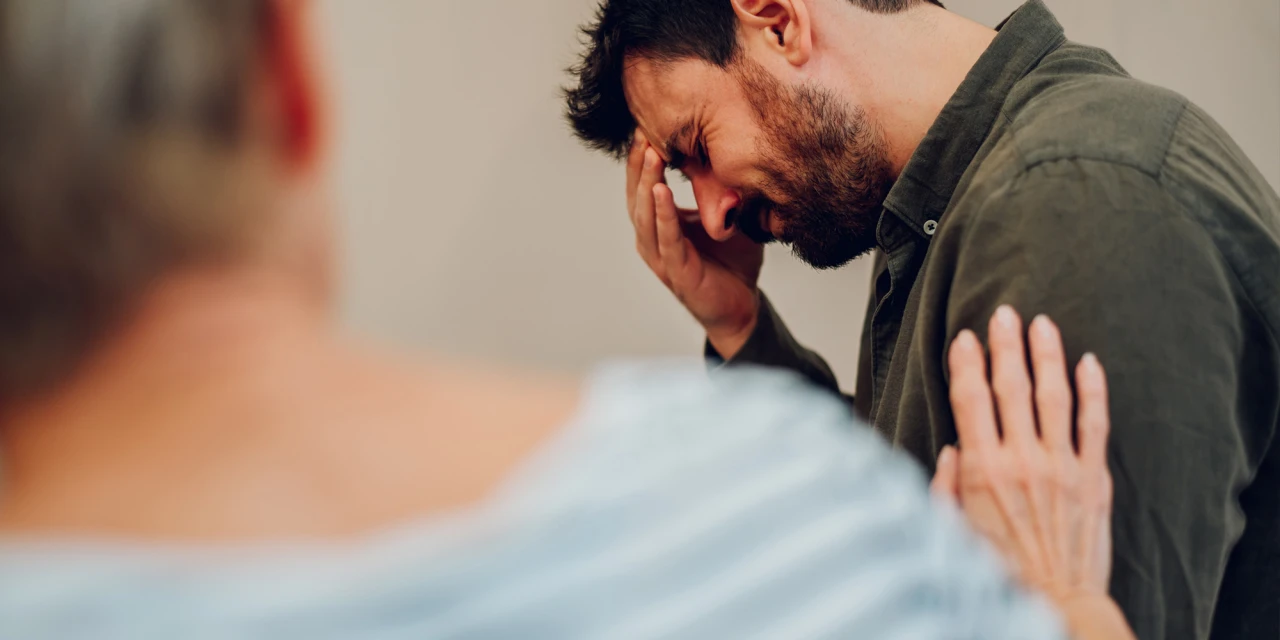 A man receives emotional support during a mental health therapy session while talking about stress, emotions and personal struggles in a safe environment.