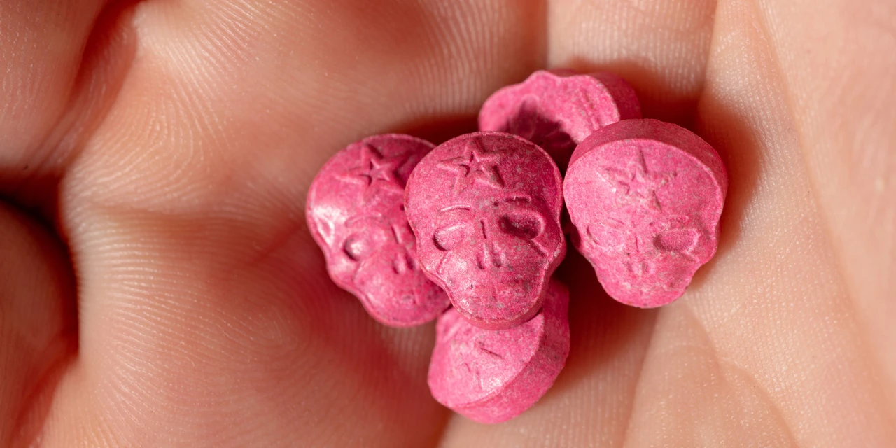 A close-up image of pink ecstasy pills shaped like skulls, showing substances commonly connected to ecstasy addiction and party drug use.