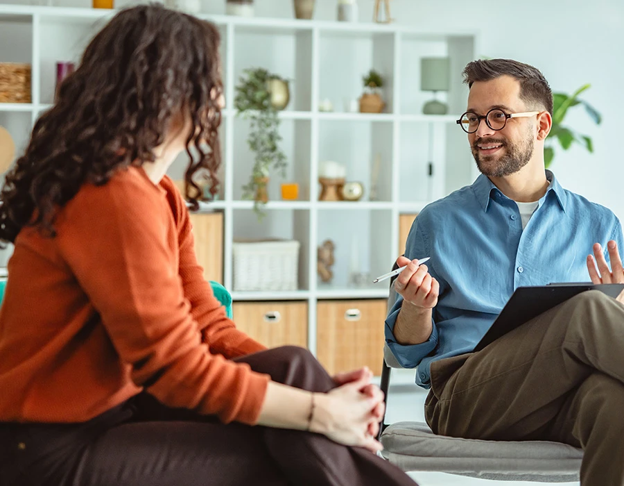 Een behandelaar voert een persoonlijk gesprek met een cliënt tijdens een behandeltraject binnen de verslavingszorg.
