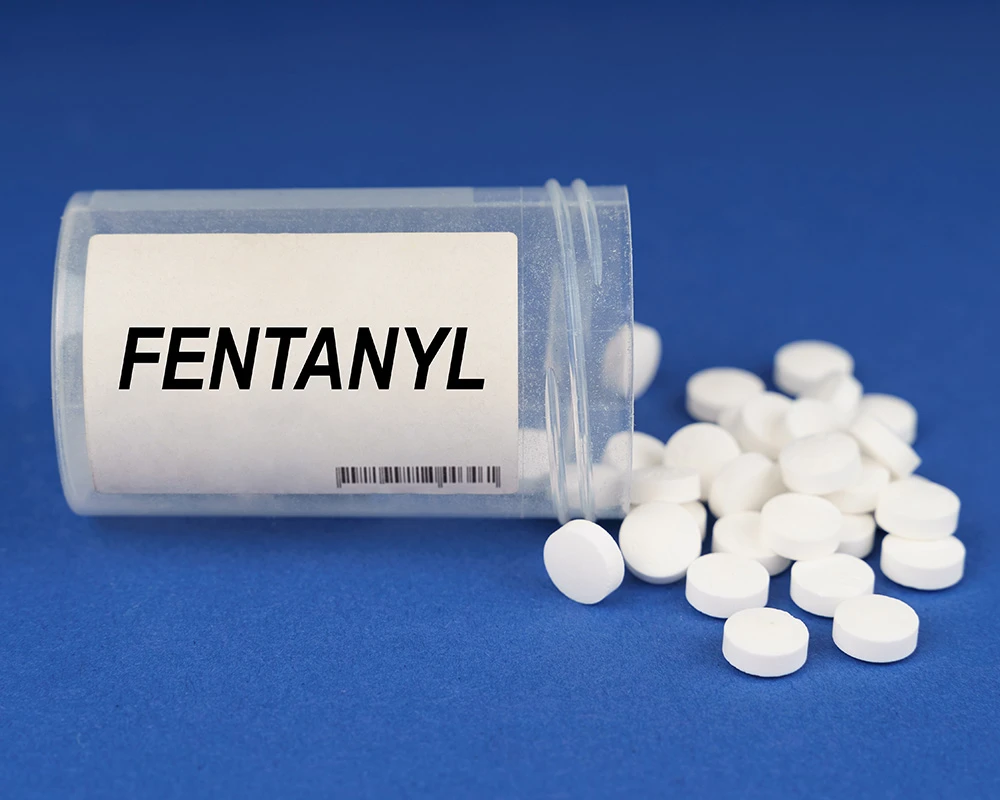 Fentanyl pills in a box with a blue background.