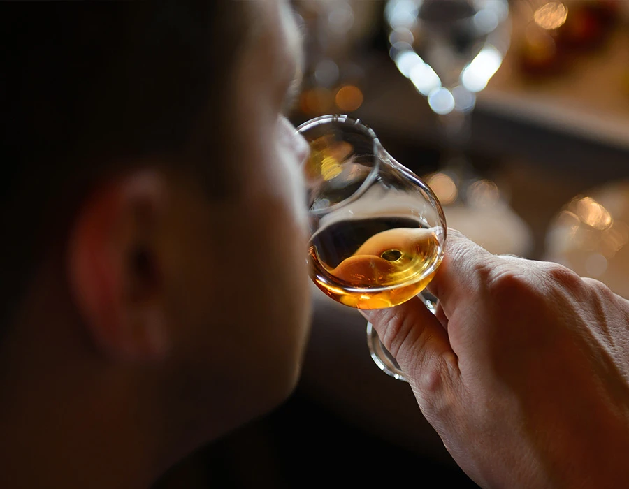 Person holding a glass of whiskey, illustrating alcohol consumption.