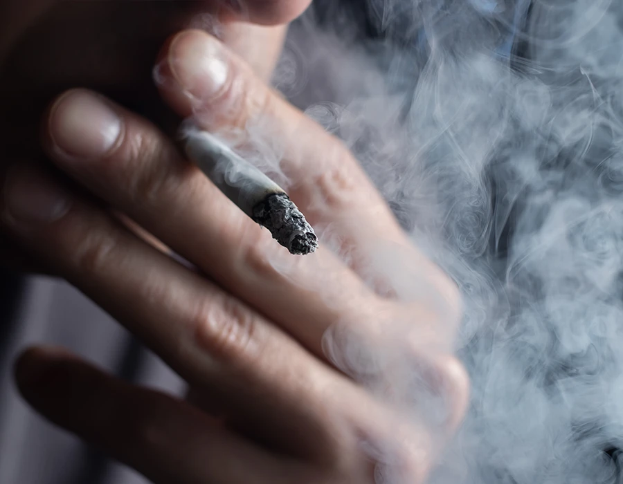 Close-up of a person smoking a joint, representing weed use