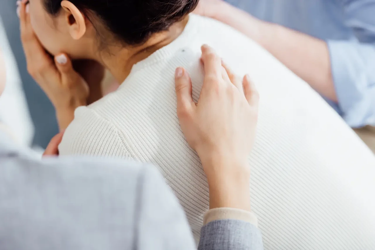 woman-being-comforted-hand-on-back