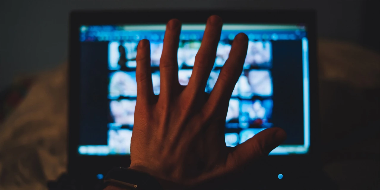 Hand voor scherm met expliciete content symbool voor seksverslaving.