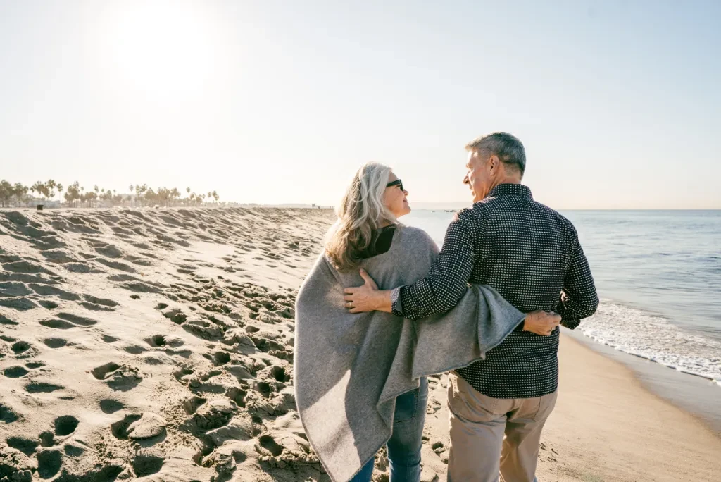 older-couple-walking-on-beach