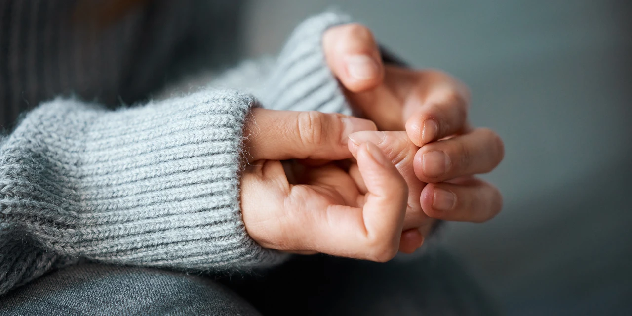 Close-up of nervous hands and fingers, symbolising inner tension, anxiety and the physical symptoms stress can create in your body.