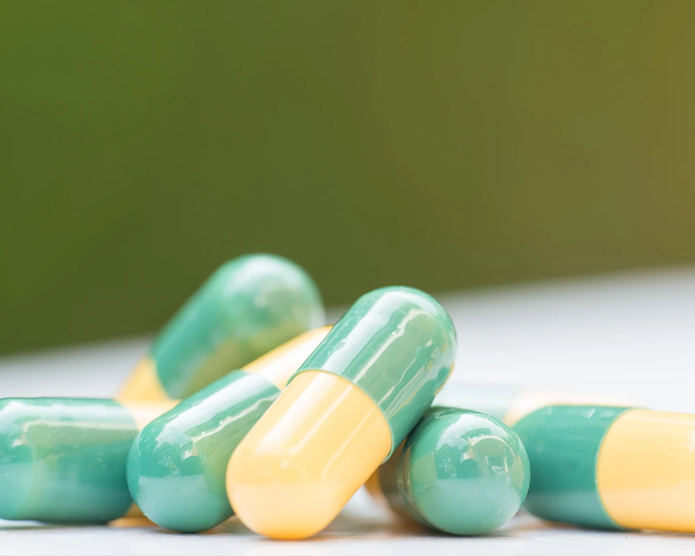 a yellow and green capsule-shaped drug.