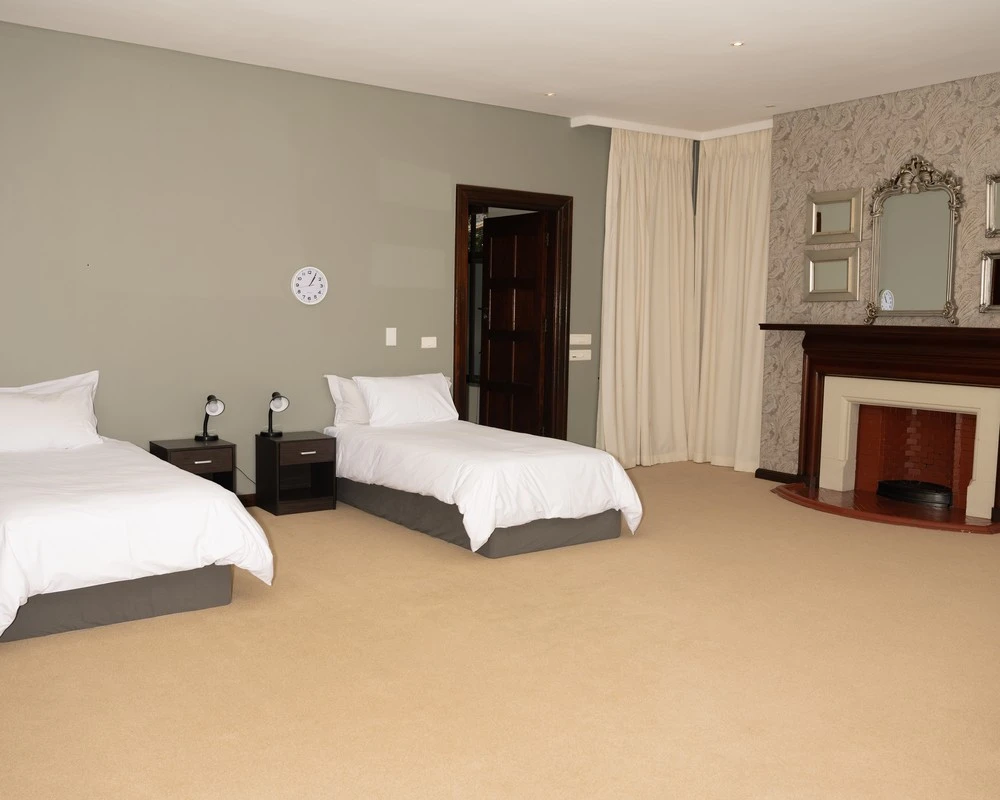 Spacious double room with a fireplace at a rehabilitation centre in South Africa.